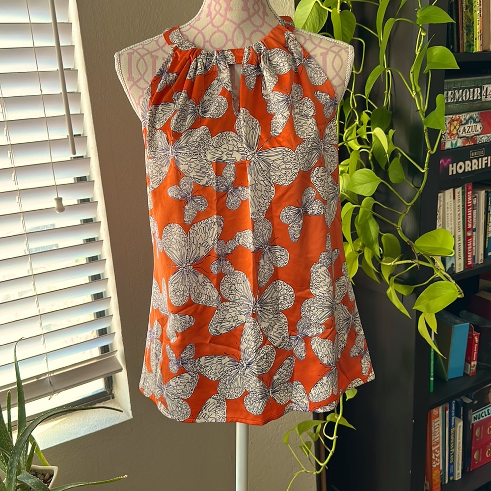Orange polyester satin sleeveless blouse.